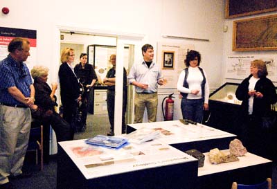 Daniel Lockett, curator of Ludlow Museum, is lauching the audio guide. People who worked on the guide and funders are standing and sitting around the geology gallery. 