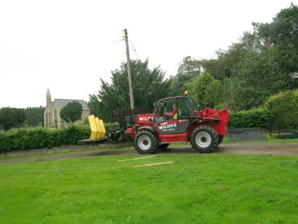 A fork-lift truck is lifting the yellow sculpture ready to load it on the to lorry.